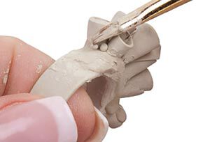Paintbrush brushing the clay smooth